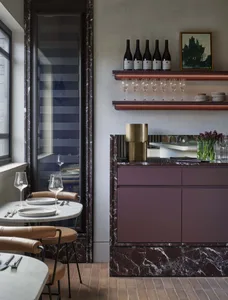 dining area with a marble table, chairs, wine glasses, cups, and bowls in a sophisticated restaurant setting