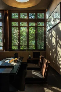 A cozy dining space with a table, chairs, and a potted plant, suggesting a warm and inviting atmosphere