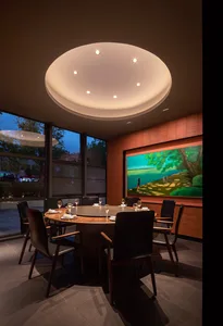 A warm and inviting dining area with a large wooden table and multiple chairs, set up for a meal or gathering