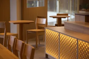 Warm and inviting restaurant interior with wooden tables and chairs, well-lit for comfortable dining