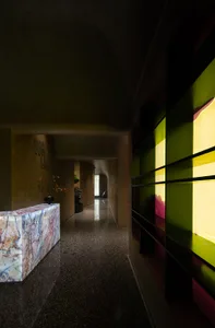 Well-lit hallway with glass panels showcasing artwork, wooden floors, and a sense of creativity and appreciation for artistic expression