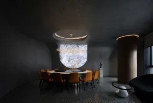 Empty modern dining space with a round table and chairs, surrounded by a couch and other furniture in a contemporary minimalist setting