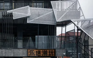A modern Asian building with a metal facade, featuring multiple levels of balconies and a striking black and white color scheme