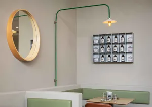 Casual dining space with wooden tables, bottles, and a relaxed atmosphere