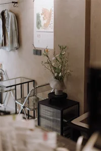 A home office with a large calendar, a vase with flowers, two chairs, and a potted plant, creating a cozy and inviting atmosphere