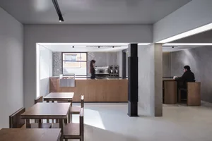 Empty restaurant interior with wooden floors and tables, and chairs with and without backs, in a clean and well-organized atmosphere