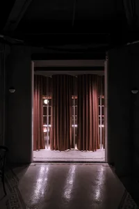 Dimly lit room with red fabric curtains, adding warmth and elegance to the space
