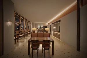 Dining area with a large wooden table and chairs, illuminated by lights, exuding sophistication and luxury