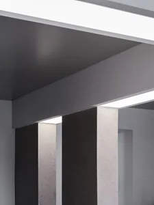 A dimly lit room with two concrete pillars, one on the left and one on the right, creating a moody atmosphere