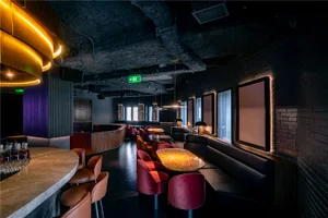 Modern restaurant interior with black and red elements, multiple chairs, and a dining table, emphasizing comfort and functionality