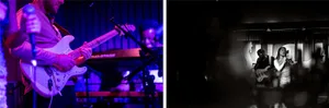 A darkened room with three people playing musical instruments, and a man standing next to a piano on stage, with a keyboard and guitar visible