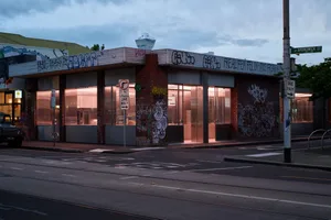 城市街景，帶有塗鴉的大樓、禁止停車標誌，以及附近停放的自行車