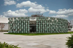 一座現代圓形設計建築，擁有玻璃立面，周圍環繞明亮而溫馨的氛圍