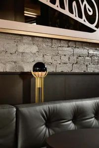 A well-lit interior design space with a couch, a lamp, and a brick wall, creating a sophisticated atmosphere