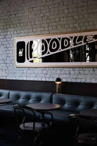 Modern restaurant interior with multiple dining tables, brick walls, and comfortable seating
