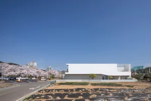 A modern building with a large white concrete facade, clean lines, and a minimalist aesthetic