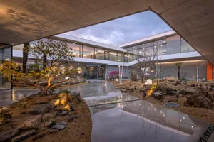 A modern building with a glass facade, concrete walls, and metal accents, featuring a mix of clean lines and minimalistic design elements