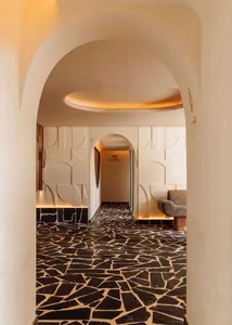 A modern hallway with a black and white checkered floor, featuring two benches and a chair, creating a stylish and inviting atmosphere