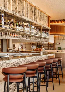 Elegant restaurant interior with a wooden bar, wine glasses, and a sophisticated atmosphere