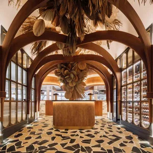 A modern restaurant interior with a wooden bar, wine glasses, and a sophisticated atmosphere