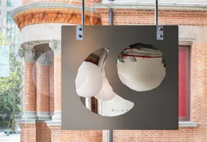A bright and inviting interior space with a large circular mirror, two lights, and a neutral background