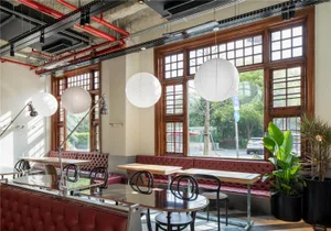 Cozy modern restaurant interior with wooden floors, white walls, and dining tables with lamps