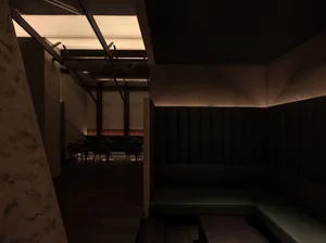 深色餐廳內部，設有大型沙發與舒適座位配置，營造神秘氛圍，適合社交與休憩