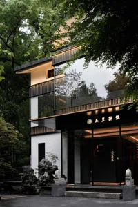 Black exterior house with a large window, natural light, and two statues in front