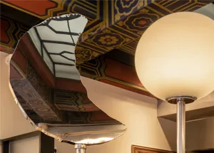 Ornate ceiling with a large mirror and wooden details, creating a sophisticated and elegant atmosphere