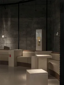 Modern interior design showroom with black and white theme, featuring two couches, a chair, and artificial lighting