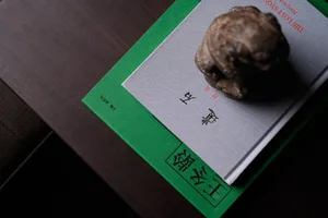 A wooden table with three books and a small stone statue arranged neatly, creating a calm and organized atmosphere