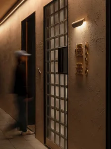 一位亞洲男子走過都市環境中玻璃門口的建築物