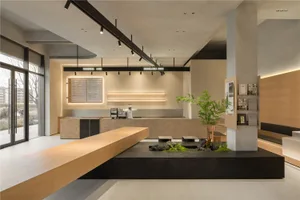 Modern restaurant interior with a large counter area, wooden counters, and potted plants