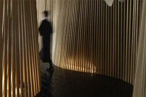 A woman walks down a calm and peaceful hallway with wooden walls and floors