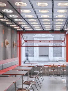 Inviting restaurant interior with red walls, tables, and chairs, creating a comfortable atmosphere for dining