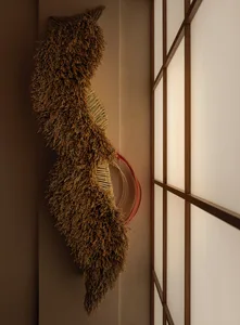 A rustic wall with a wooden frame and a hanging object made of straw or hay, set against a neutral background