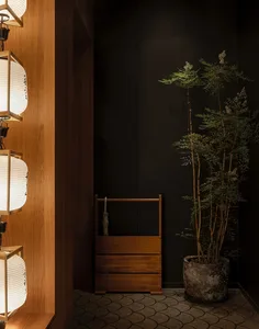 A well-lit bedroom with wooden walls and floors, featuring a bed and potted plants for a warm and inviting atmosphere