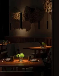 Warm and inviting dining area with multiple wooden tables and chairs, featuring a vase on one table