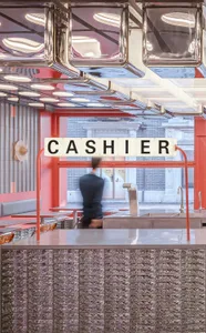 A casual restaurant cashier area with a counter, chairs, and a dining table, two people present