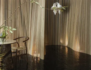 A modern dining space with a wooden table and chairs, surrounded by bamboo panelled walls in a black and white theme