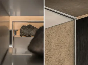 Cozy living space with a wood floor, carpeted area, and a glass case displaying rocks, with a couch present