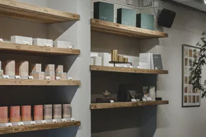 A store display featuring various products on wooden shelves, with bottles and books arranged in an organized manner, creating a clean and well-organized atmosphere
