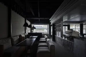 Elegant cafe interior with black and white color scheme, multiple couches, a dining table, and chairs