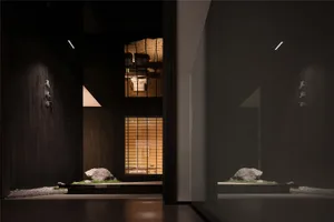 A well-lit modern living room with a large window, two decorative rocks, and a potted plant