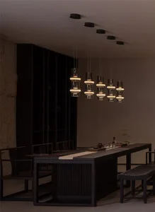 A warm and inviting restaurant interior with a large wooden dining table surrounded by chairs and bottles, perfect for socializing and enjoying meals together