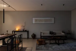 A modern living room with a large couch, dining table, chair, vases, and a potted plant, set in a contemporary and minimalist style