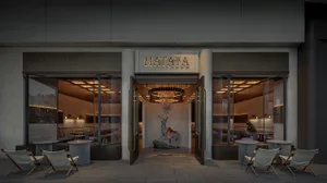 A spacious restaurant interior with multiple dining tables and chairs, creating a warm and inviting atmosphere