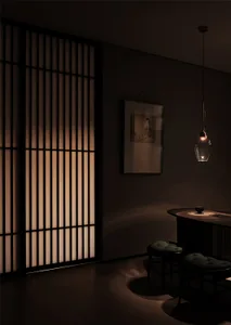 A dimly lit bar area with a counter, chairs, and a couch in a modern space with gray walls and wooden elements