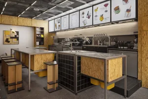 Industrial kitchen with multiple sinks, countertops, and various items on display