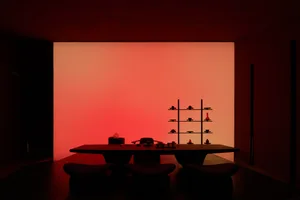Dining area with a wooden table and three chairs, creating a warm and inviting atmosphere for meals and socializing
